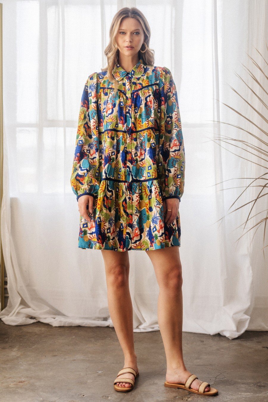 Model wearing a Poppy Baby Doll Shirt Dress from a Port Aransas boutique, ideal for stylish beach outings and tropical vacations.