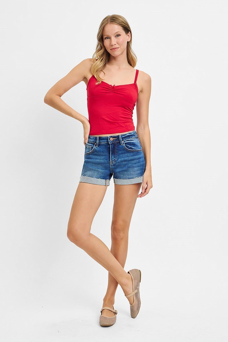 Model wearing Risen Low Rise Dark Cuffed Shorts with a red top, showcasing coastal boutique clothing styles.