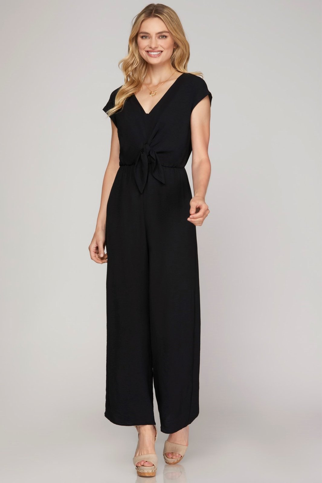 Elegant black jumpsuit featuring a tie waist, perfect for coastal boutique clothing and tropical vacations.
