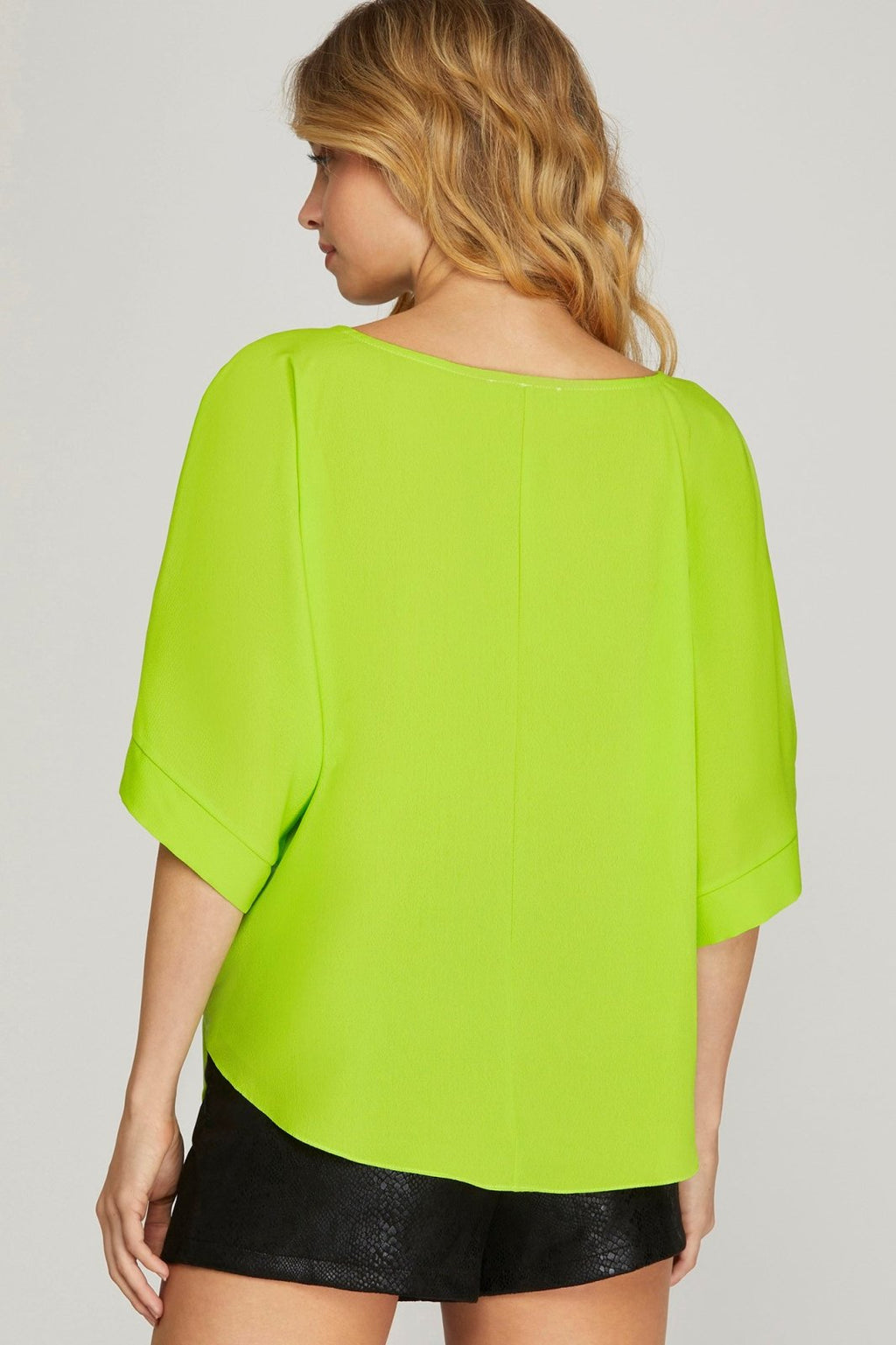 Back view of a woman wearing the Lime Side-Tie Top from Raggdoll Boutique, perfect for summer outfits in Port Aransas.