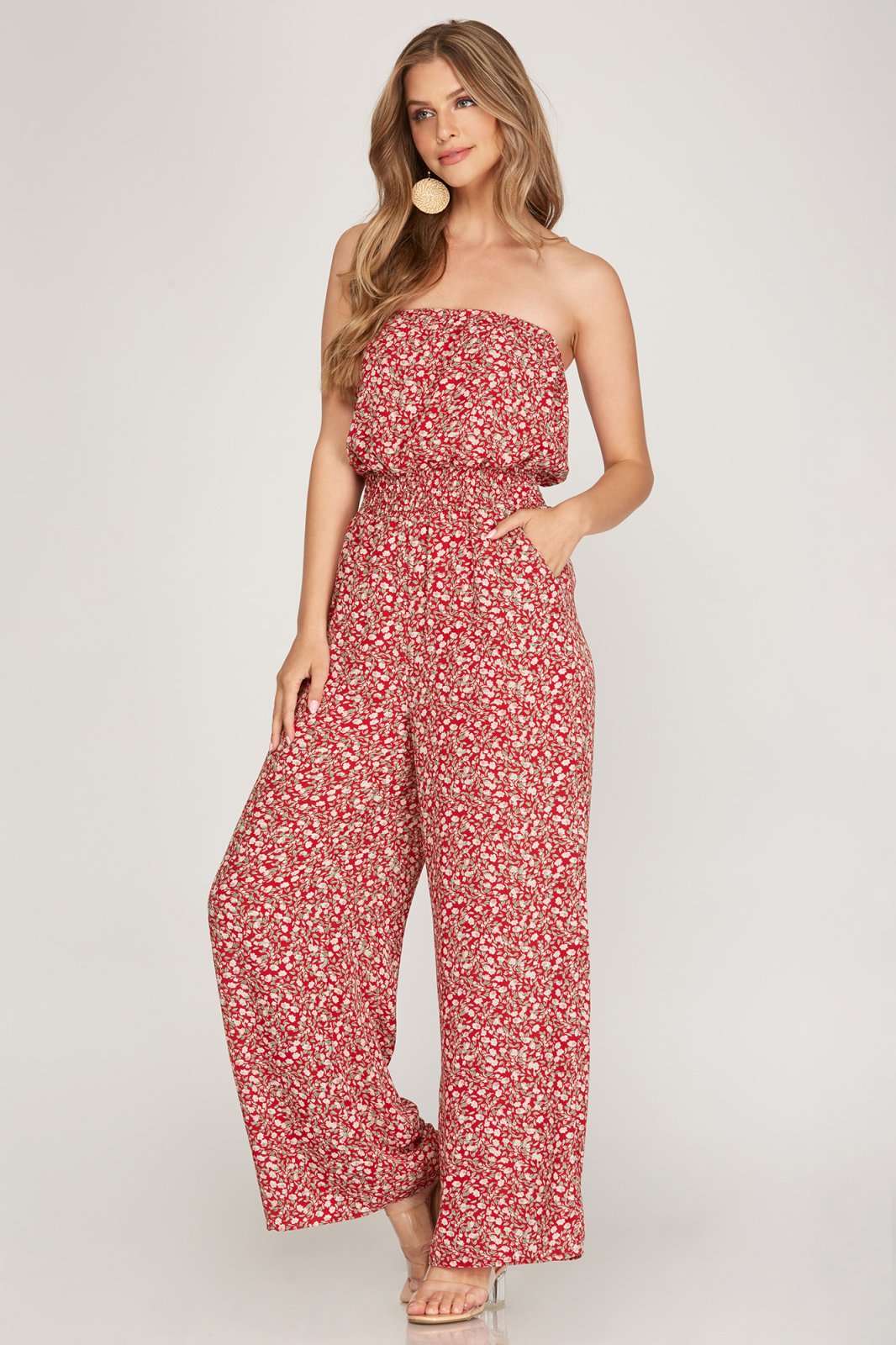 Stylish woman wearing a RED FLORAL STRAPLESS JUMPSUIT from Raggdoll Boutique, perfect for summer outfits Texas.