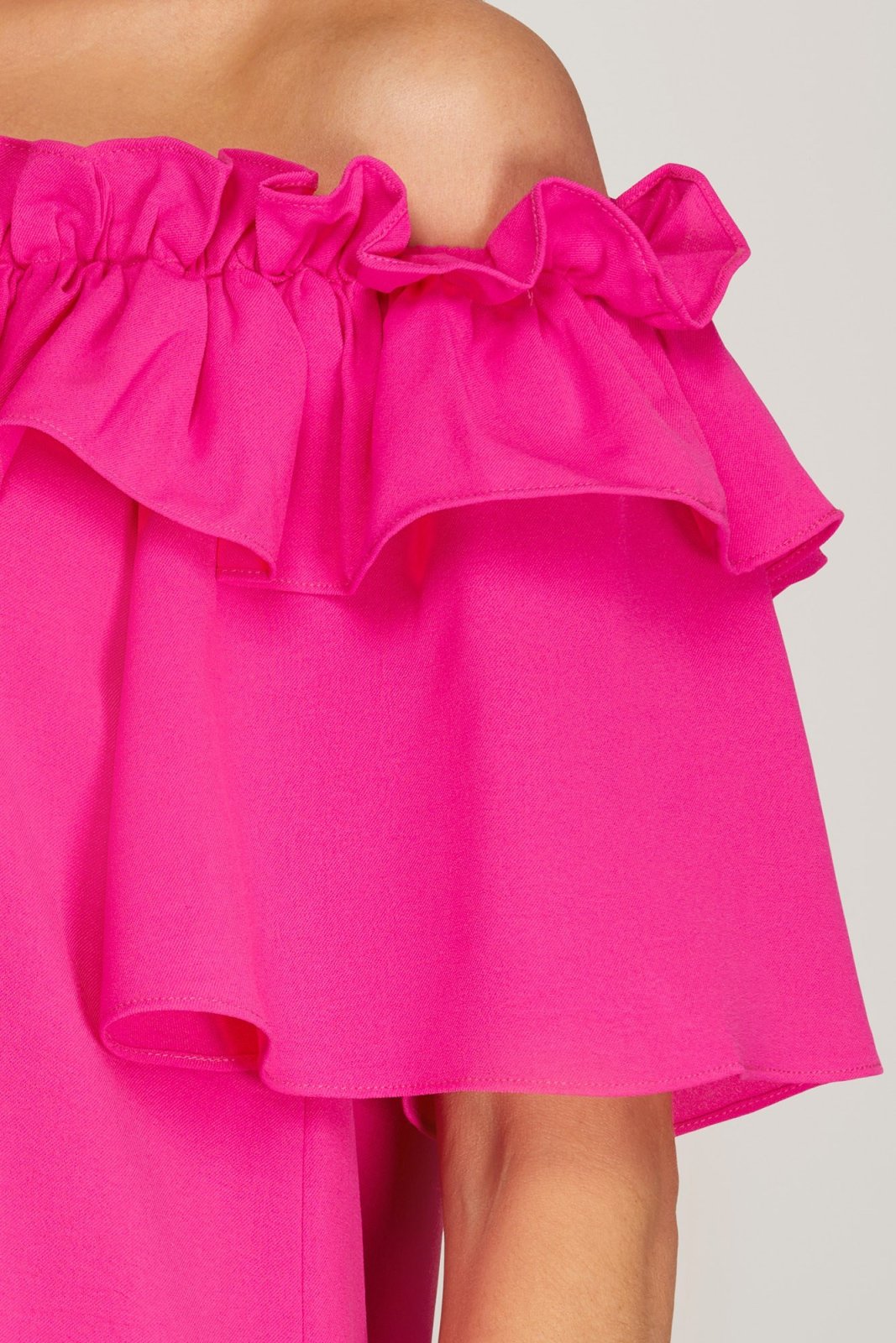Close-up of the PINK PASSION OFF-SHOULDER DRESS showcasing its ruffled neckline and vibrant pink fabric.