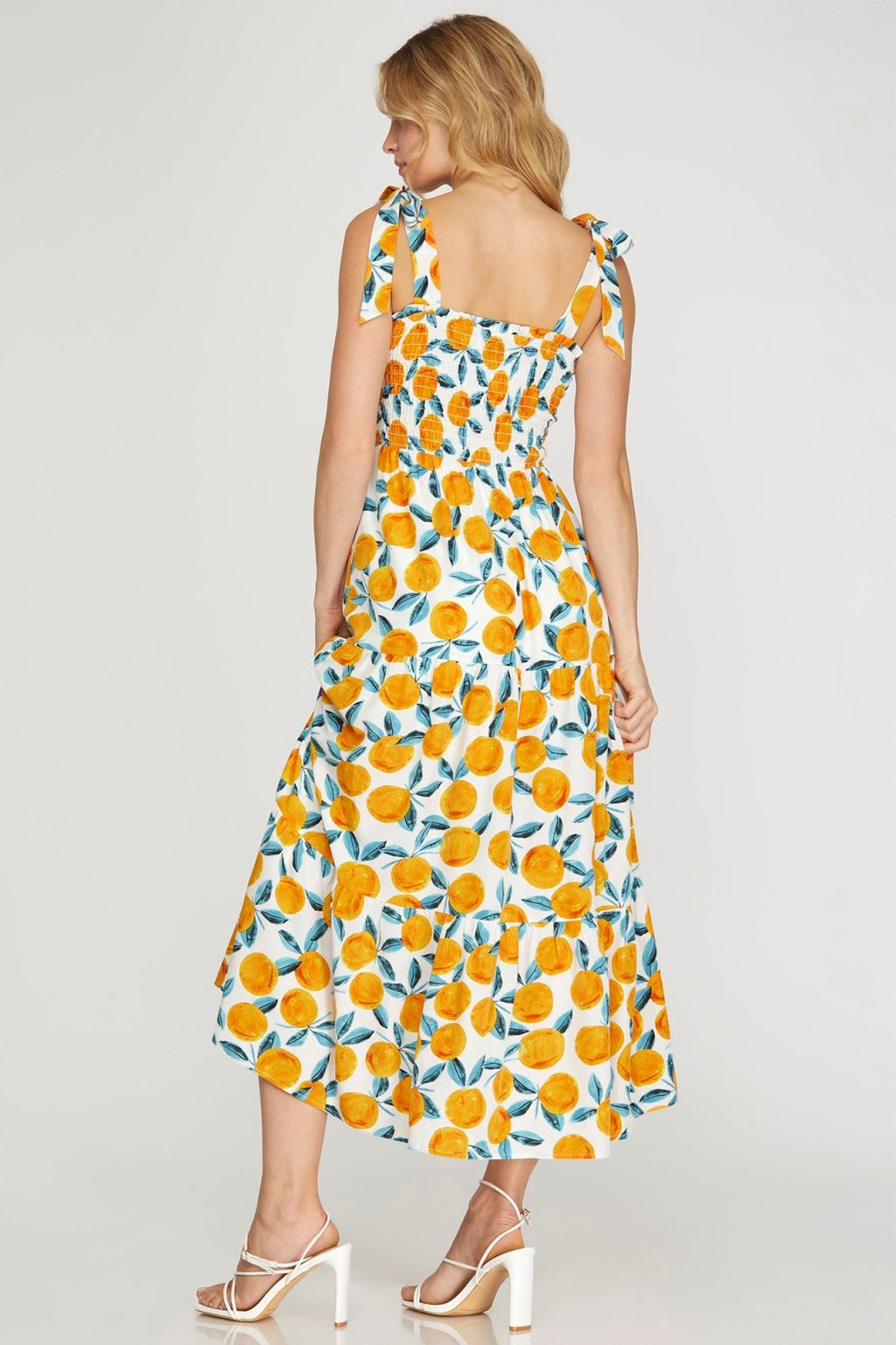 Back view of the Orange You in Love Dress!! featuring a citrus print and shoulder ties, perfect for summer outfits Texas.