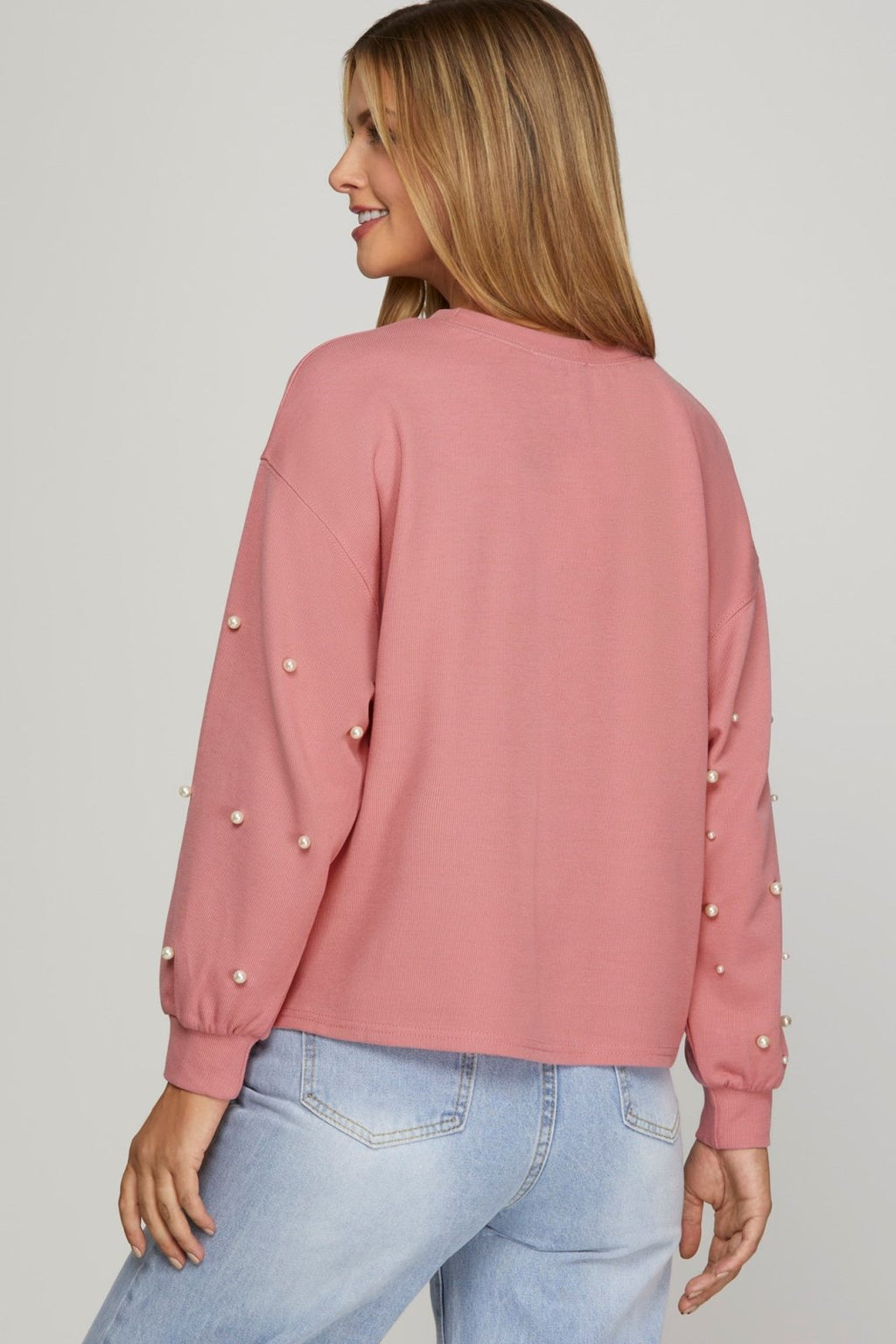 Back view of a stylish pink long sleeve top with pearl details, perfect for coastal boutique clothing and curvy fashion.