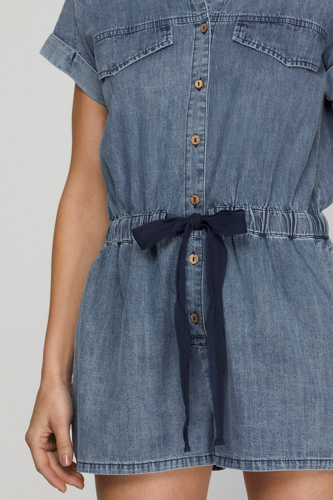 Denim blue romper with button front and tie waist, perfect for coastal boutique clothing and curvy plus size fashion.