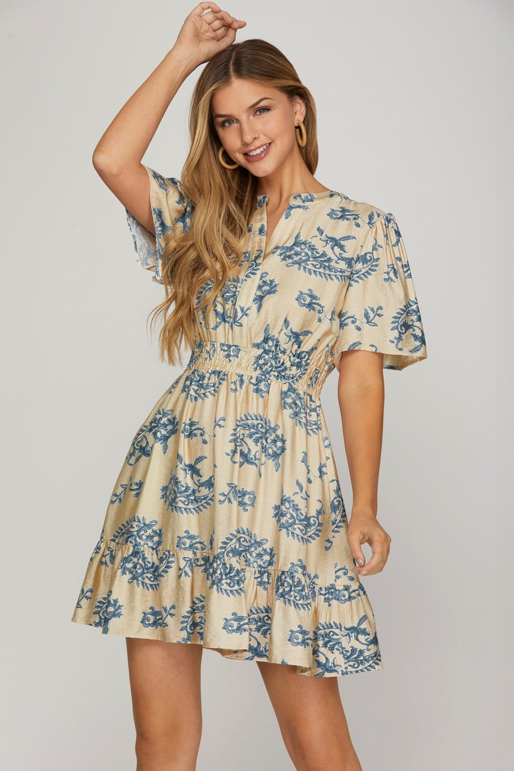 Carla dress from a coastal boutique, featuring a blue print on a cream mini dress, perfect for beach outings and vacations.