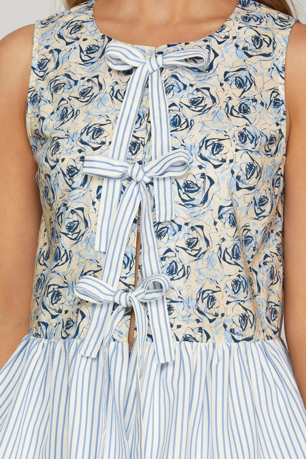 Chic sleeveless Cat Top with floral print and front bow tie detail, perfect for sunny days, available at coastal boutique.