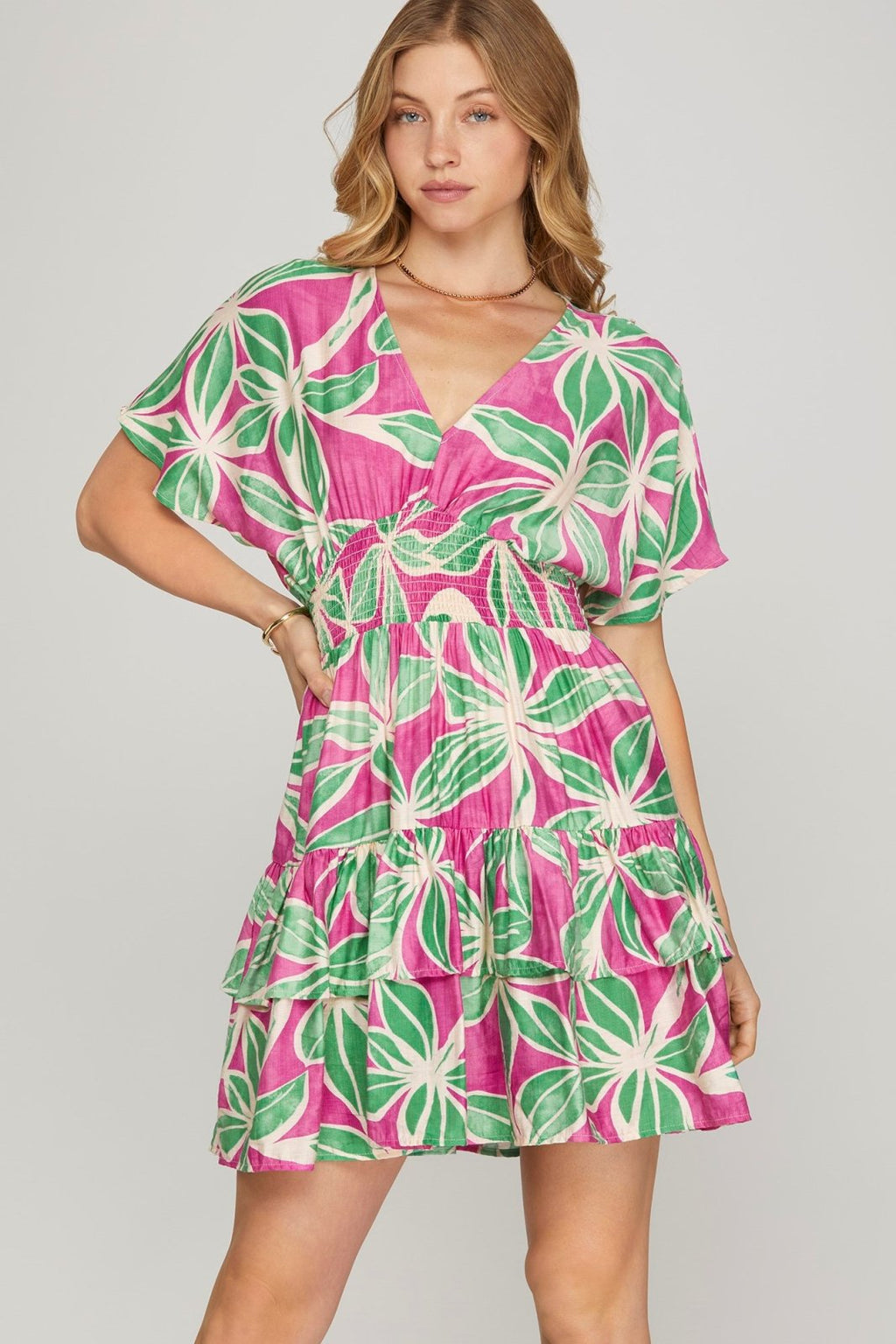 Dreamy pink and green floral mini dress from a coastal boutique, perfect for tropical vacations and spring parties.