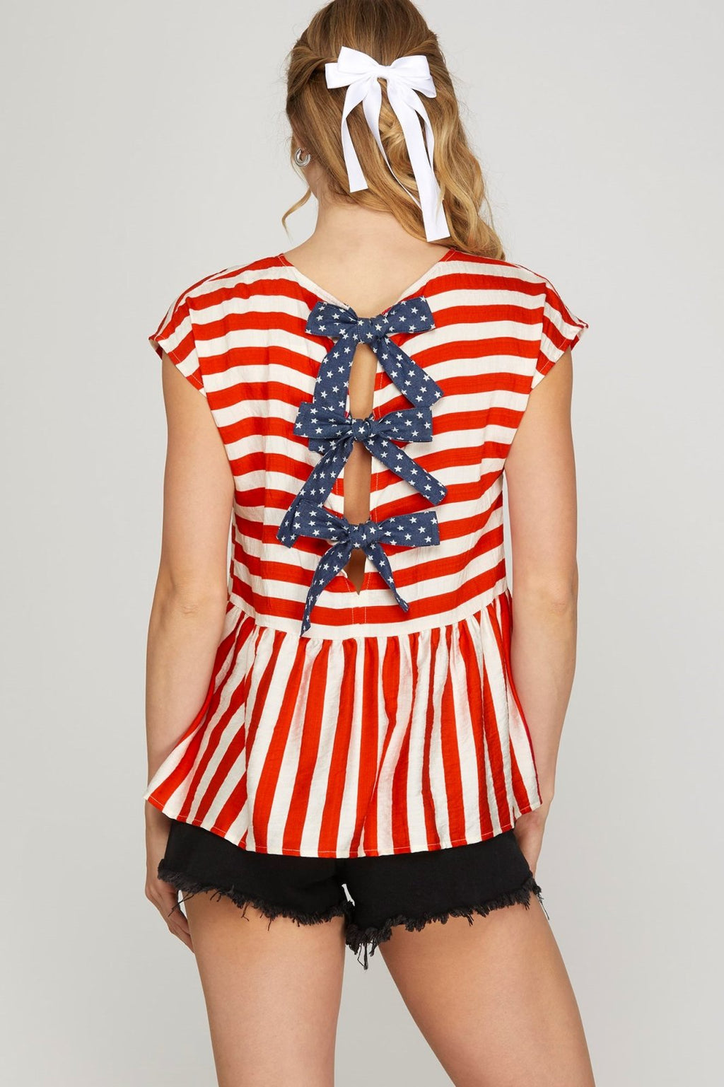 Red striped top with drop shoulder and bow tie back, perfect for casual outings from a coastal boutique.