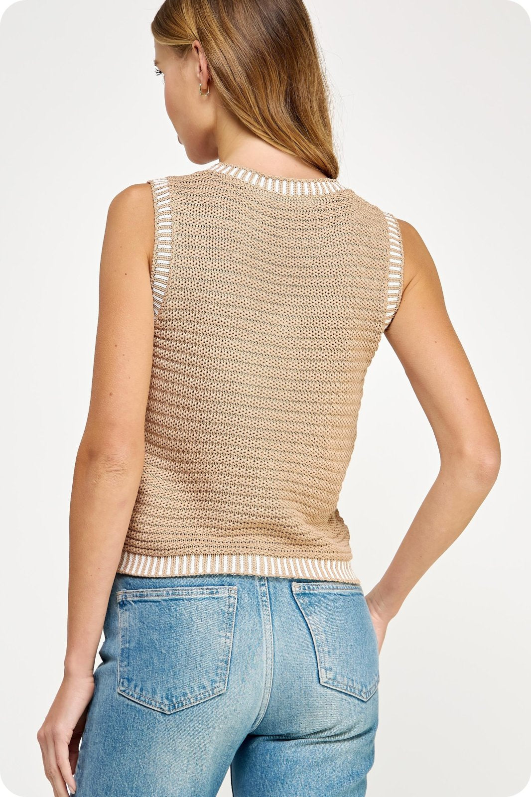 Stylish taupe crochet vest at a coastal boutique, perfect for layering with beach dresses and curvy plus size fashion.