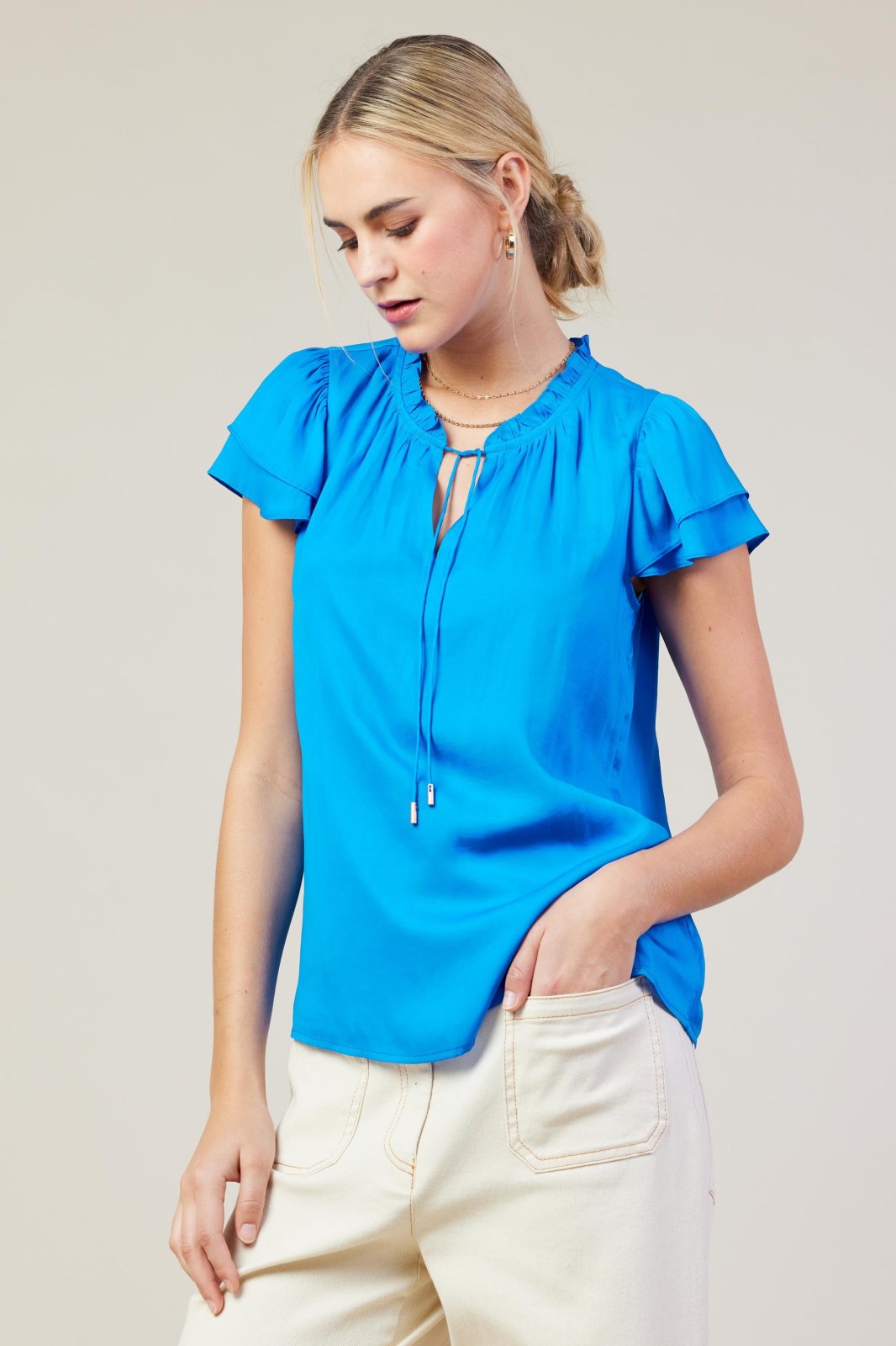 Vivid blue top featuring ruffle sleeves, perfect for coastal boutique clothing, stylish casual outings, and tropical vacations.