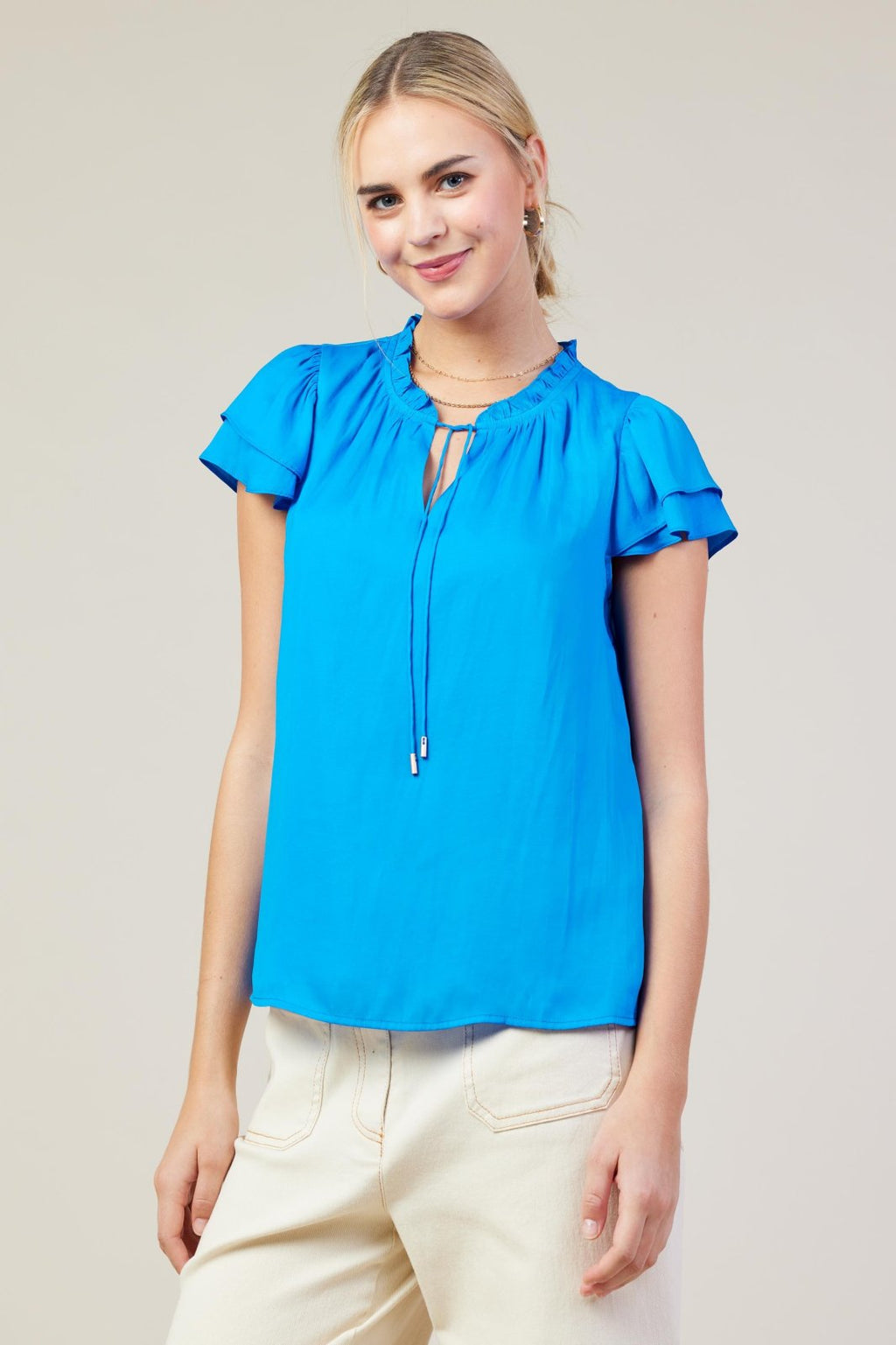 Vivid blue top with ruffle sleeves, perfect for casual outings and stylish for coastal boutique clothing.