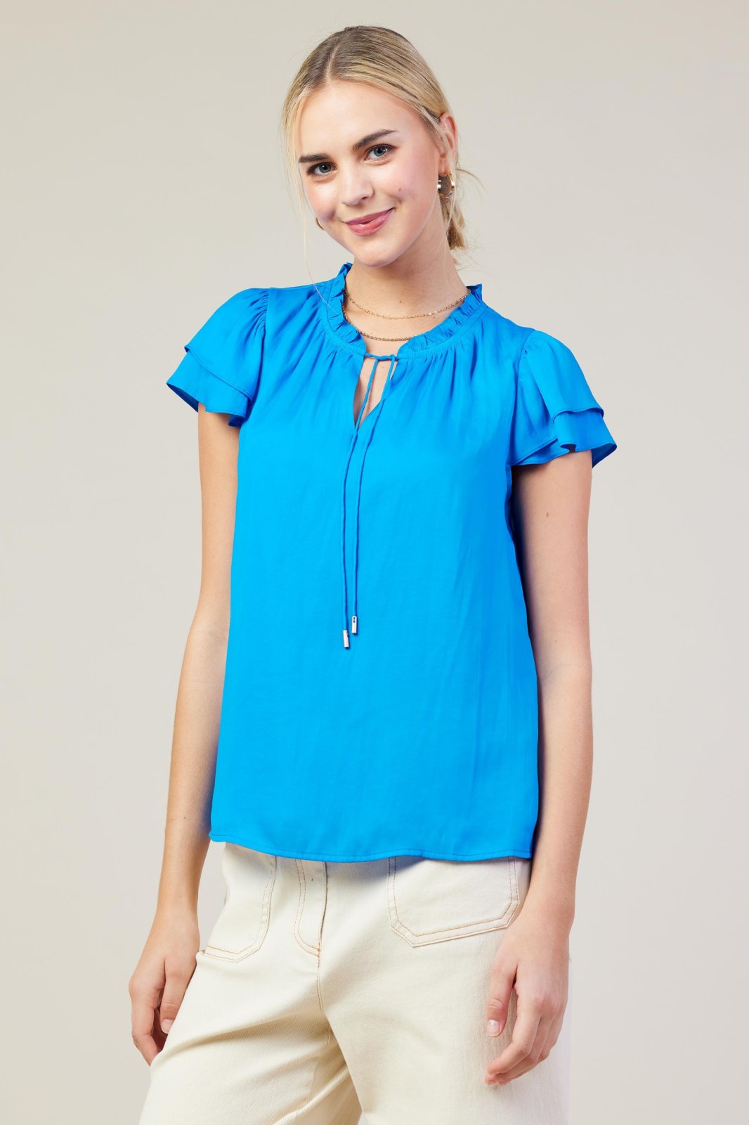 Vivid blue top with ruffle sleeves, perfect for casual outings and stylish for coastal boutique clothing.