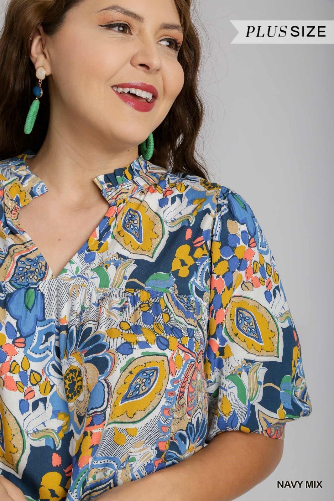 Plus size woman in a colorful floral top showcasing coastal boutique clothing and curated women's fashion.