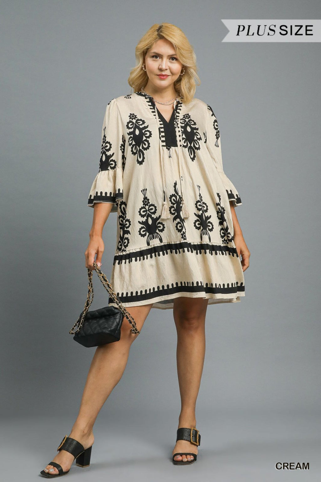 Stylish cream mini dress with black border print, perfect for coastal boutique clothing and tropical vacations.