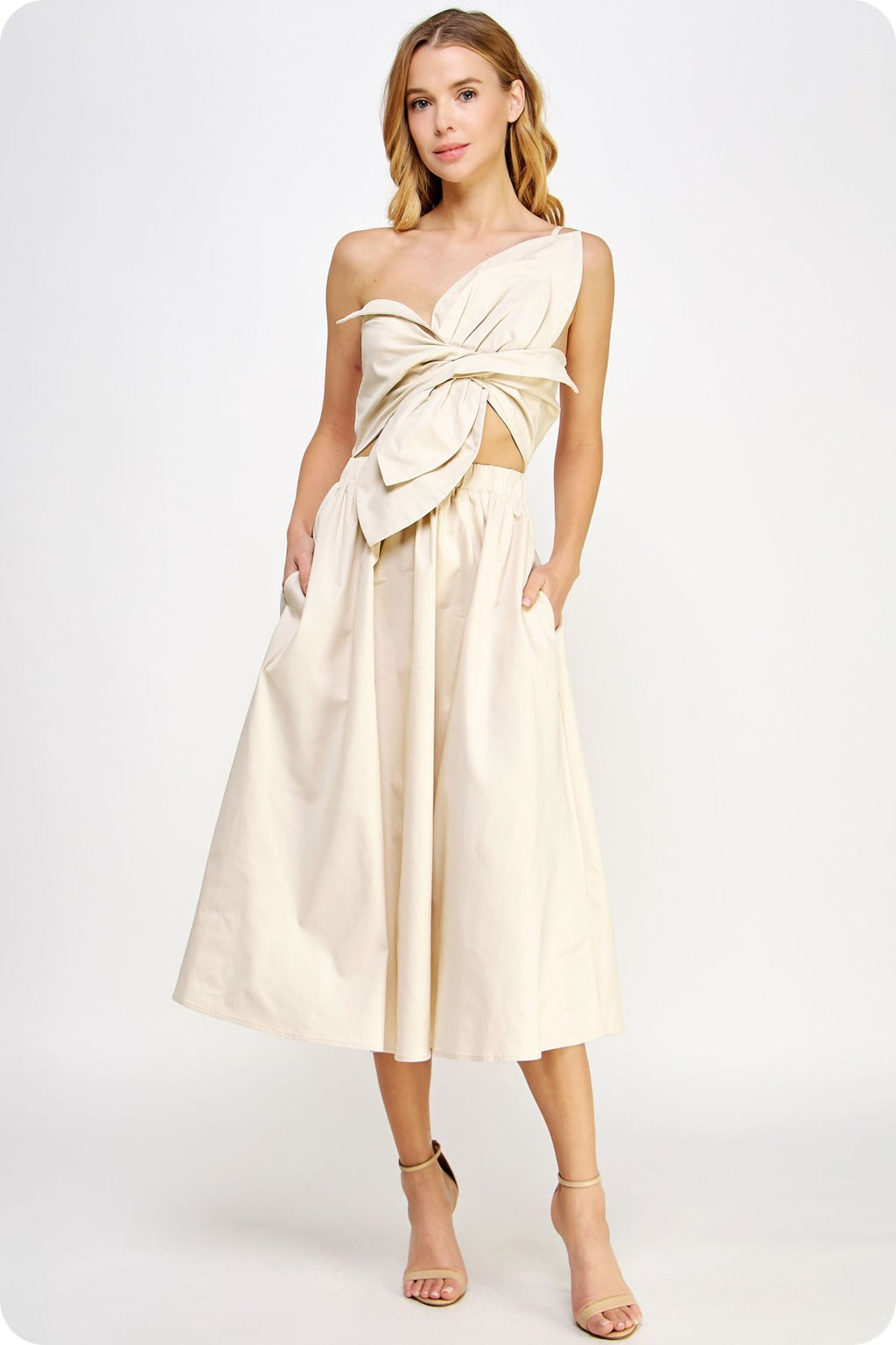 Ecru Structure Dress showcasing a unique twisted bow, one shoulder design, and elasticated waist, ideal for trendy coastal style.