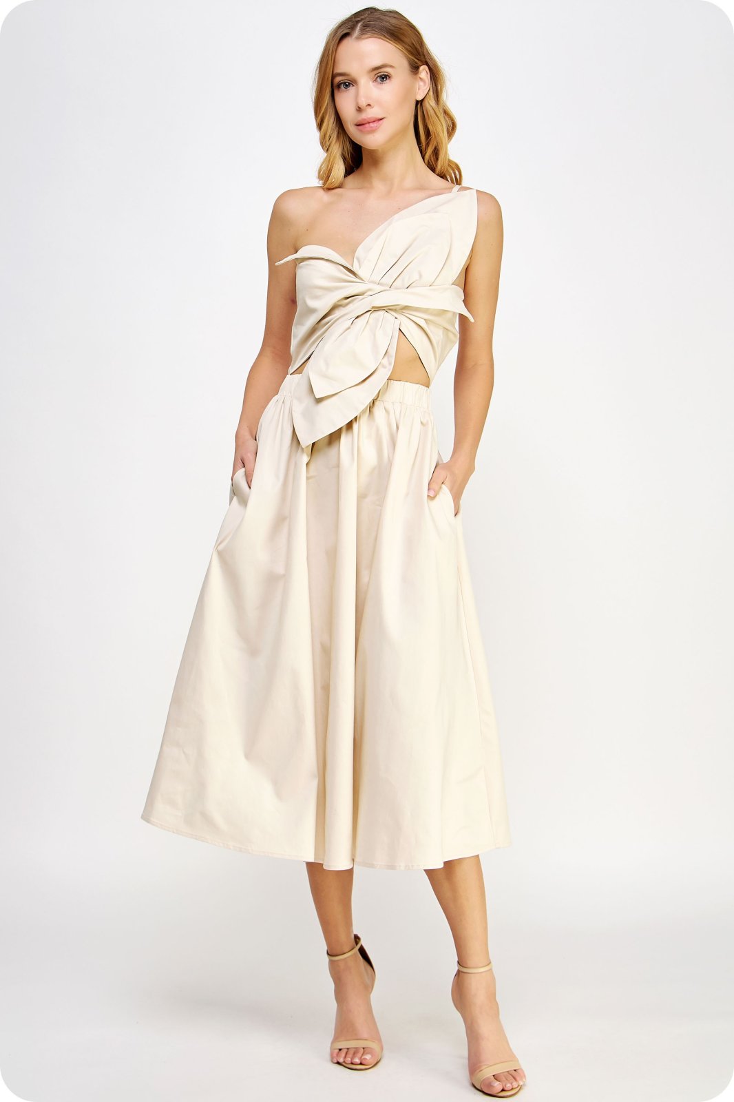 Ecru Structure Dress showcasing a unique twisted bow, one shoulder design, and elasticated waist, ideal for trendy coastal style.