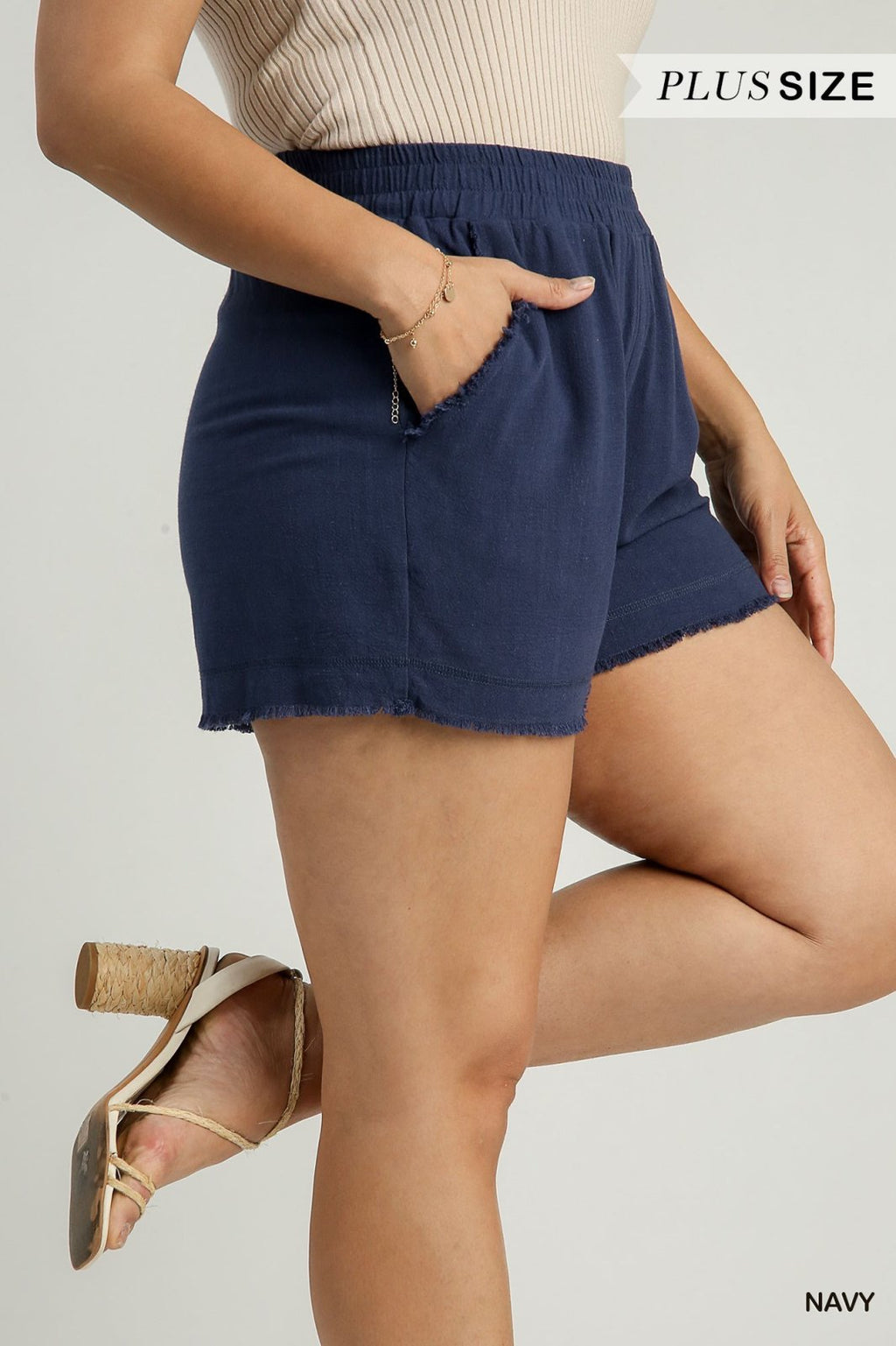 Plus-size navy frayed hem shorts with elastic waistband and side pockets for summer comfort, ideal for coastal boutique clothing.