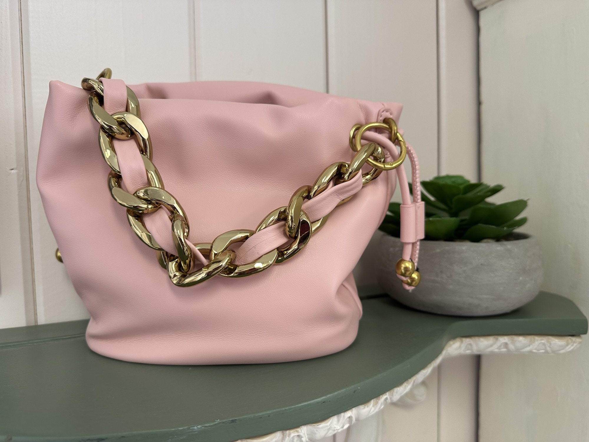 Cute soft pink purse with gold chain strap, perfect for stylish women seeking trendy, compact crossbody options.