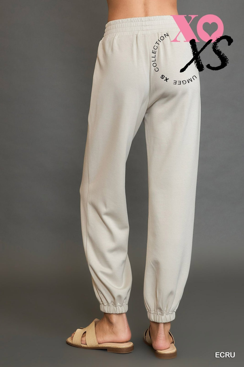 Ecru jogger suit showcased at a boutique, perfect for coastal styles and tropical vacations. Stylish women's bottoms.