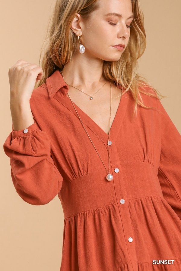 Woman wearing a SUNSET TIERED DRESS with layered necklaces, showcasing trendy coastal style from Raggdoll Boutique.