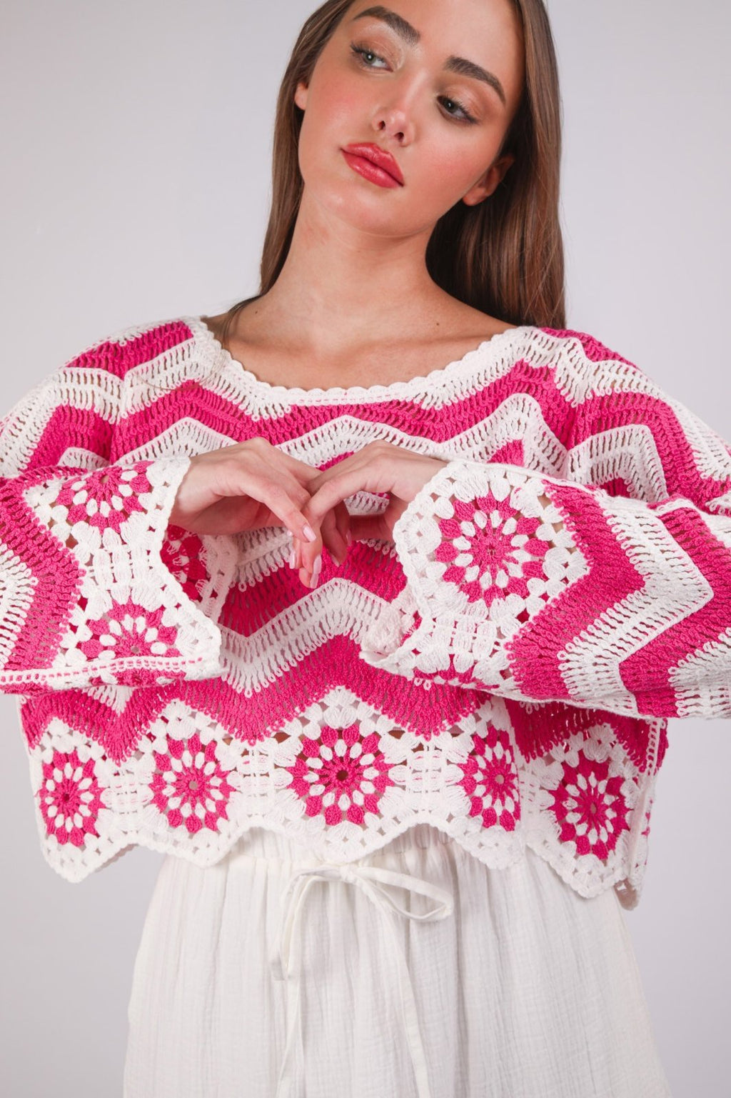 Pink Chevron Crochet Knit Top from a coastal boutique, perfect for layering and adding a pop of color to beach dresses.