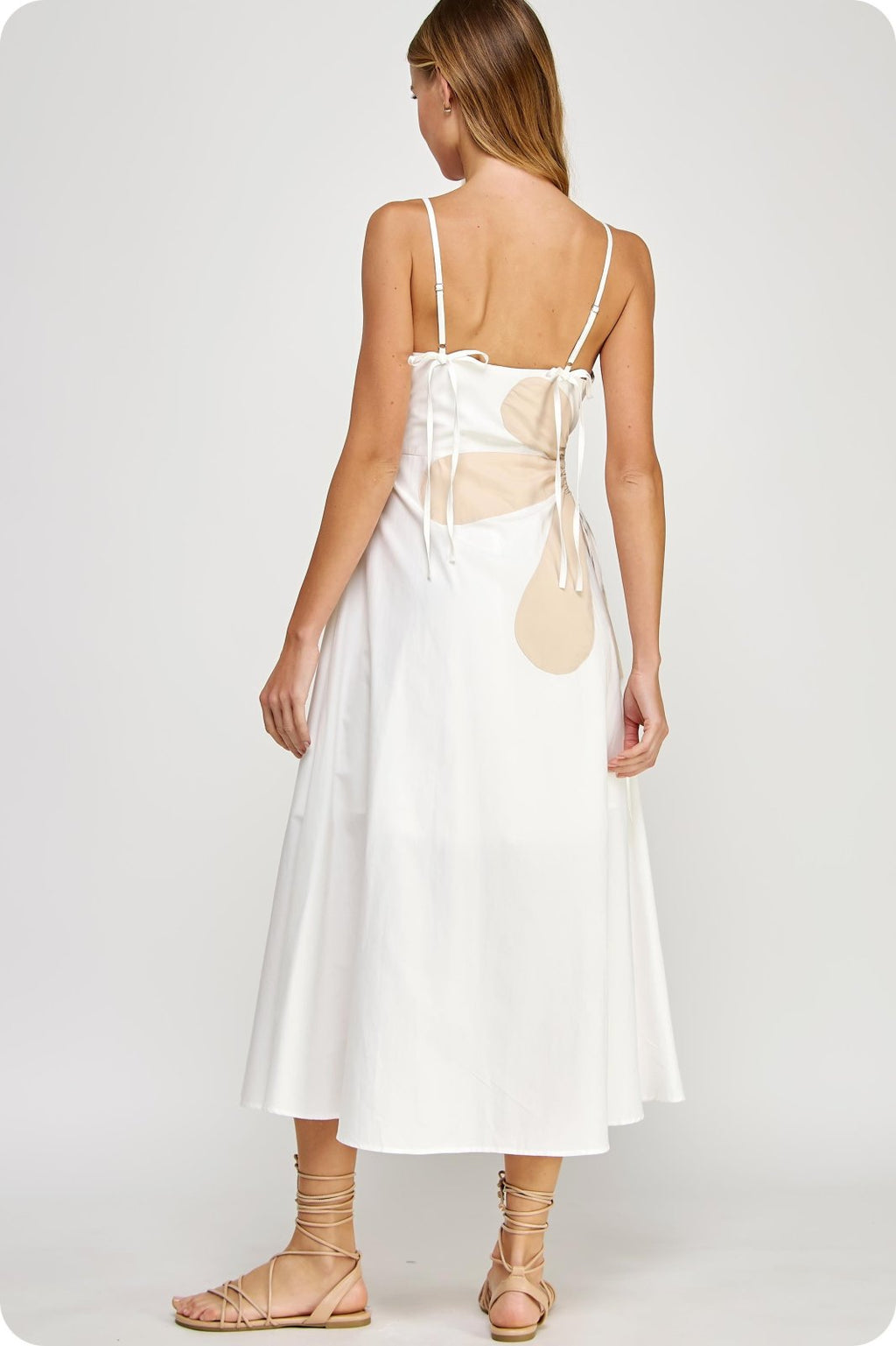 Back view of the Addison Dress, an off-white sleeveless maxi dress with a side cutout and adjustable straps, perfect for beach outings.