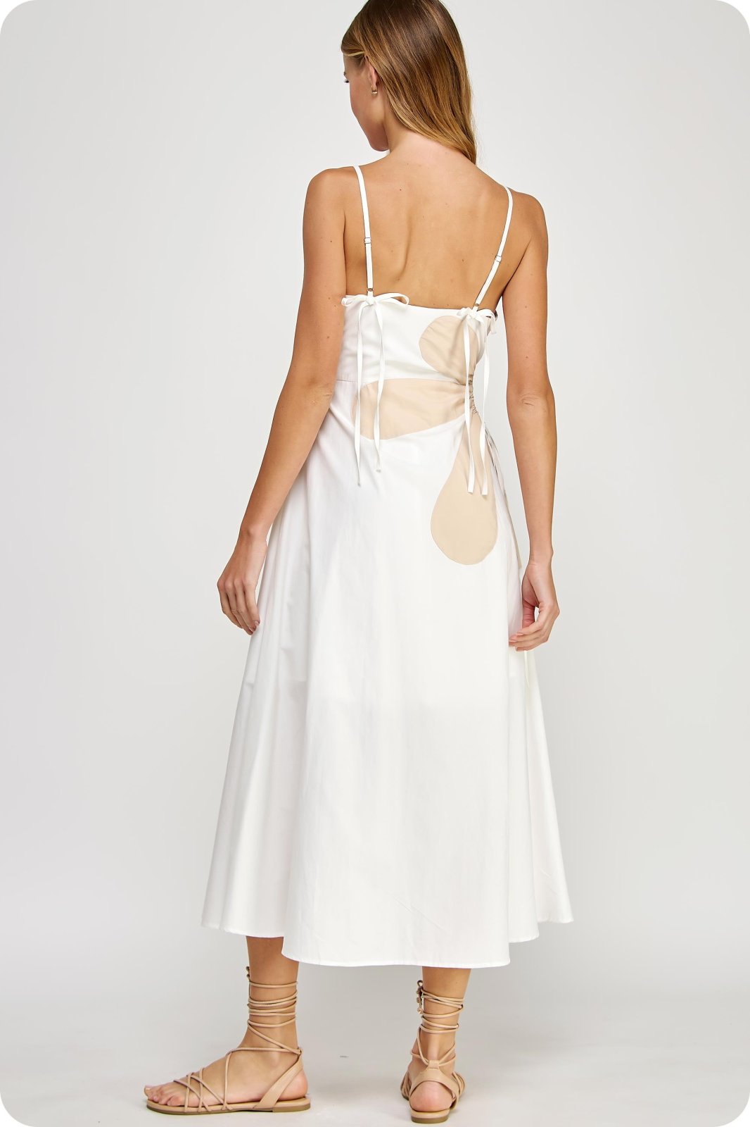 Back view of the Addison Dress, an off-white sleeveless maxi dress with a side cutout and adjustable straps, perfect for beach outings.