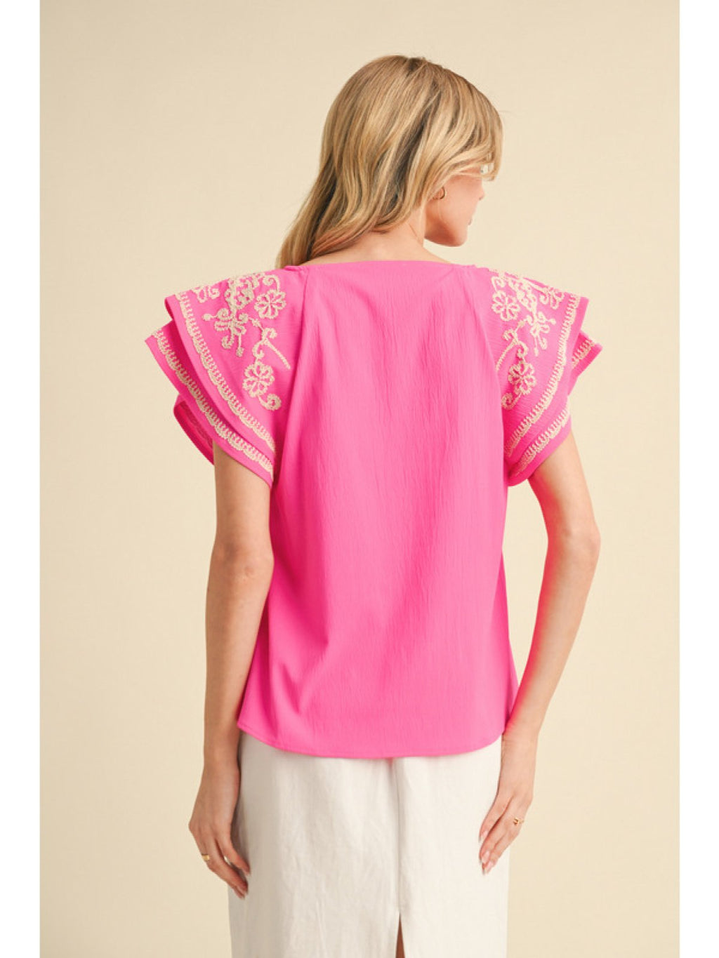 Stylish Amy Top in hot pink with embroidered flutter sleeves, perfect for casual outings and coastal boutique clothing.