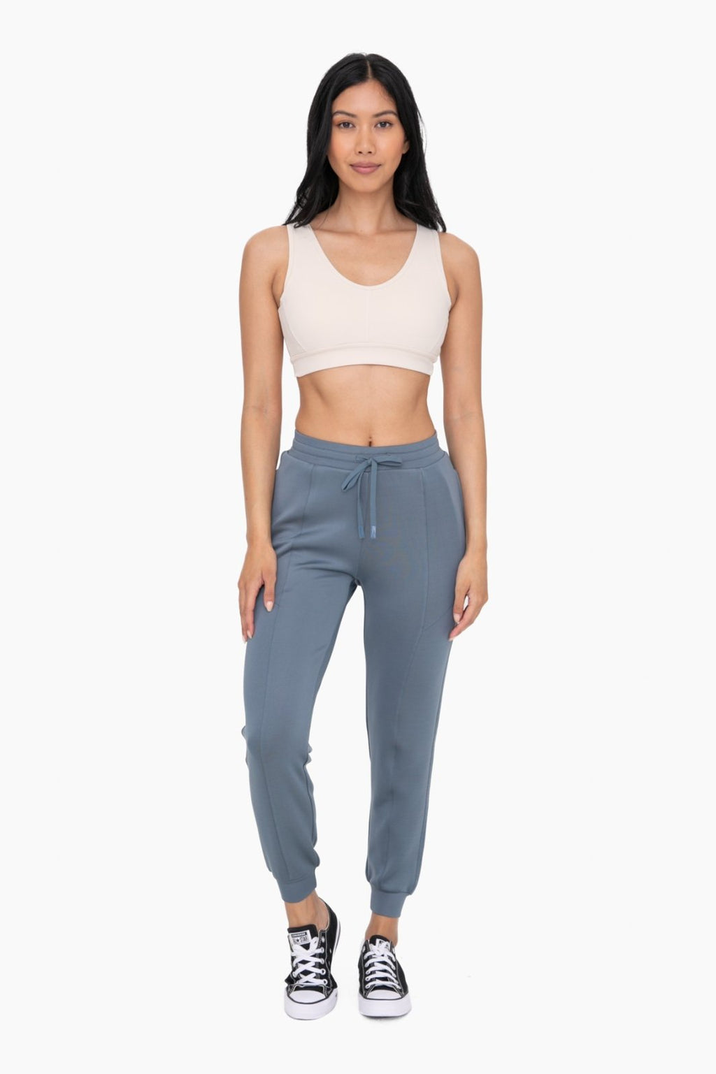 Stylish model in blue cuffed joggers with zipper pockets, showcasing coastal boutique clothing for curvy women's fashion.