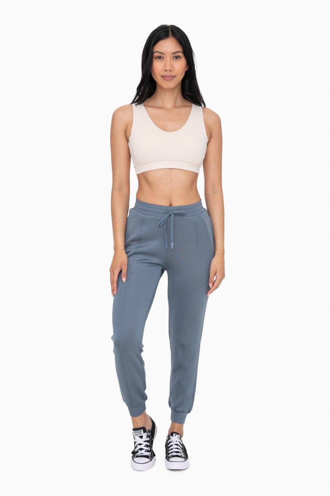Stylish model in blue cuffed joggers with zipper pockets, showcasing coastal boutique clothing for curvy women's fashion.