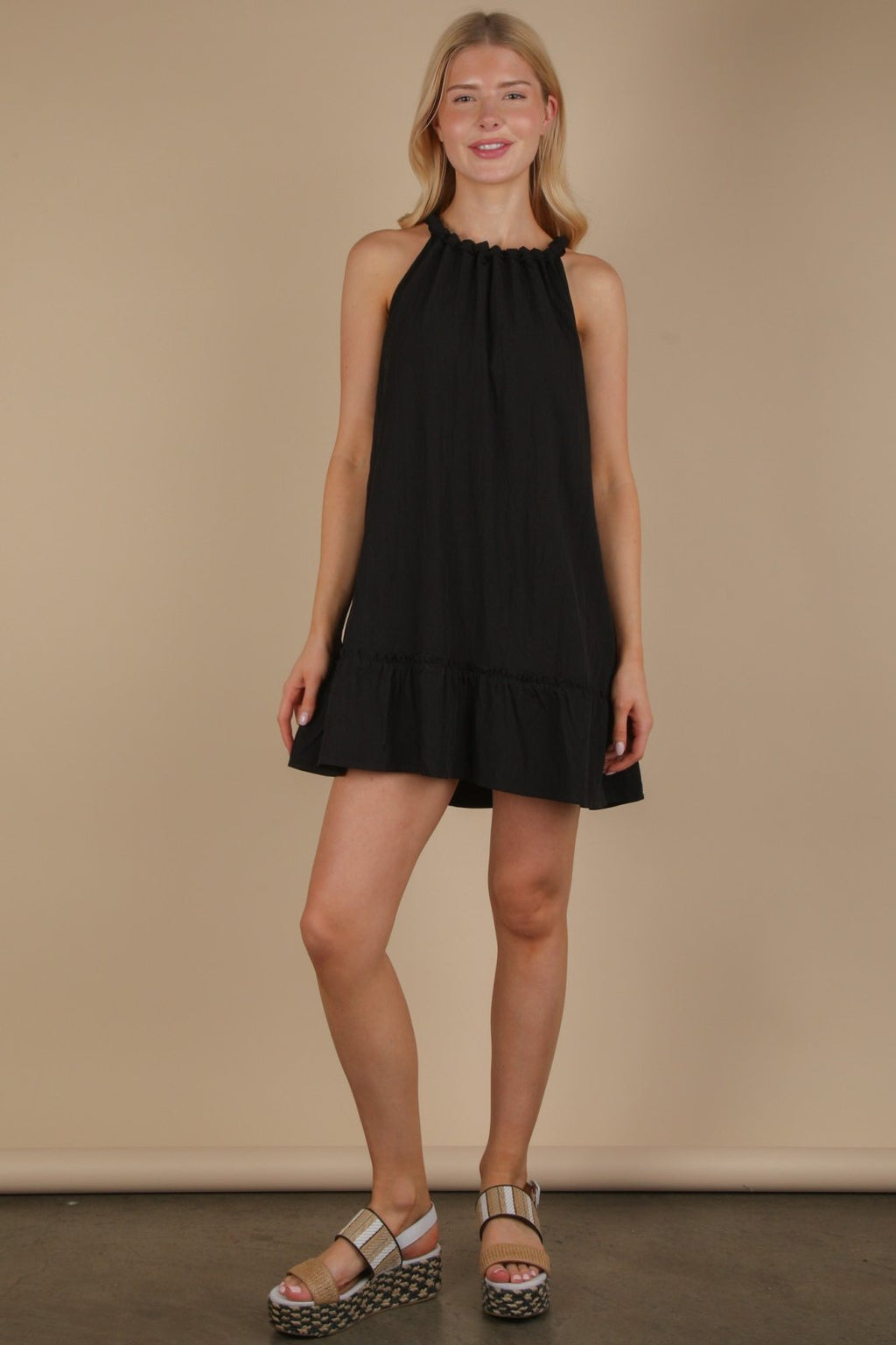 Stylish black halter neck ruffle mini dress from a coastal boutique, perfect for summer beach outings and tropical vacations.