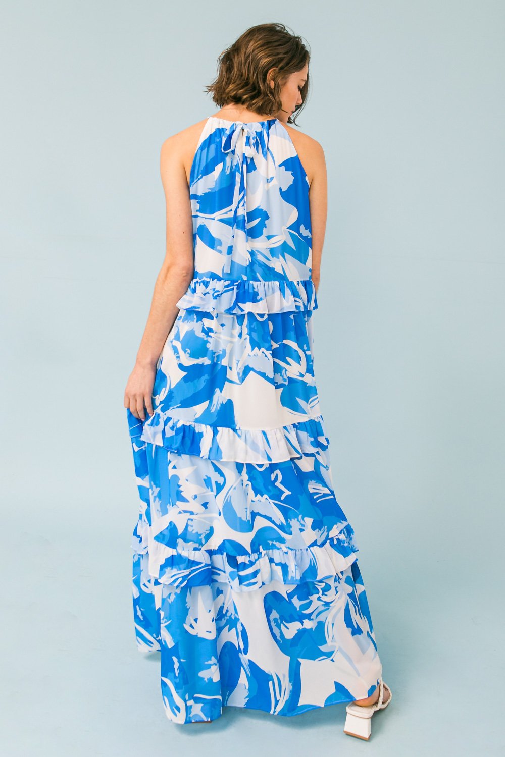 Elegant blue and white tiered halter maxi dress, perfect for coastal boutique clothing and tropical vacation styles.
