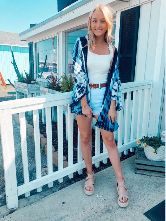 A model wearing a BLUE TIE-DYE KIMONO over a tank top and shorts, showcasing trendy coastal style from Raggdoll Boutique.