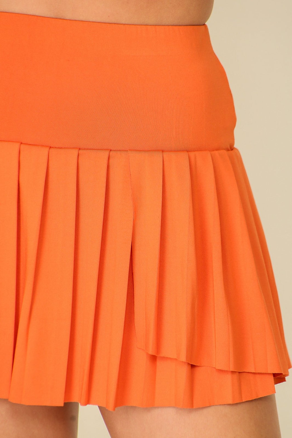 Burnt orange pleated skirt from coastal boutique clothing, perfect for beach outings and casual vacations.