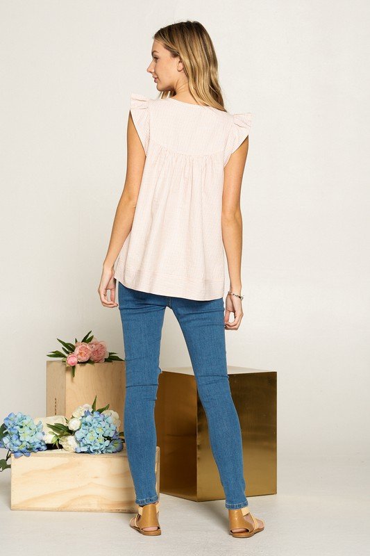CORAL SEER SUCKER TOP WITH EMBROIDERY worn with blue jeans, showcasing trendy coastal style from Raggdoll Boutique.