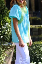Woman wearing THE COVE TOP from Raggdoll Boutique, showcasing trendy coastal style in Port Aransas.