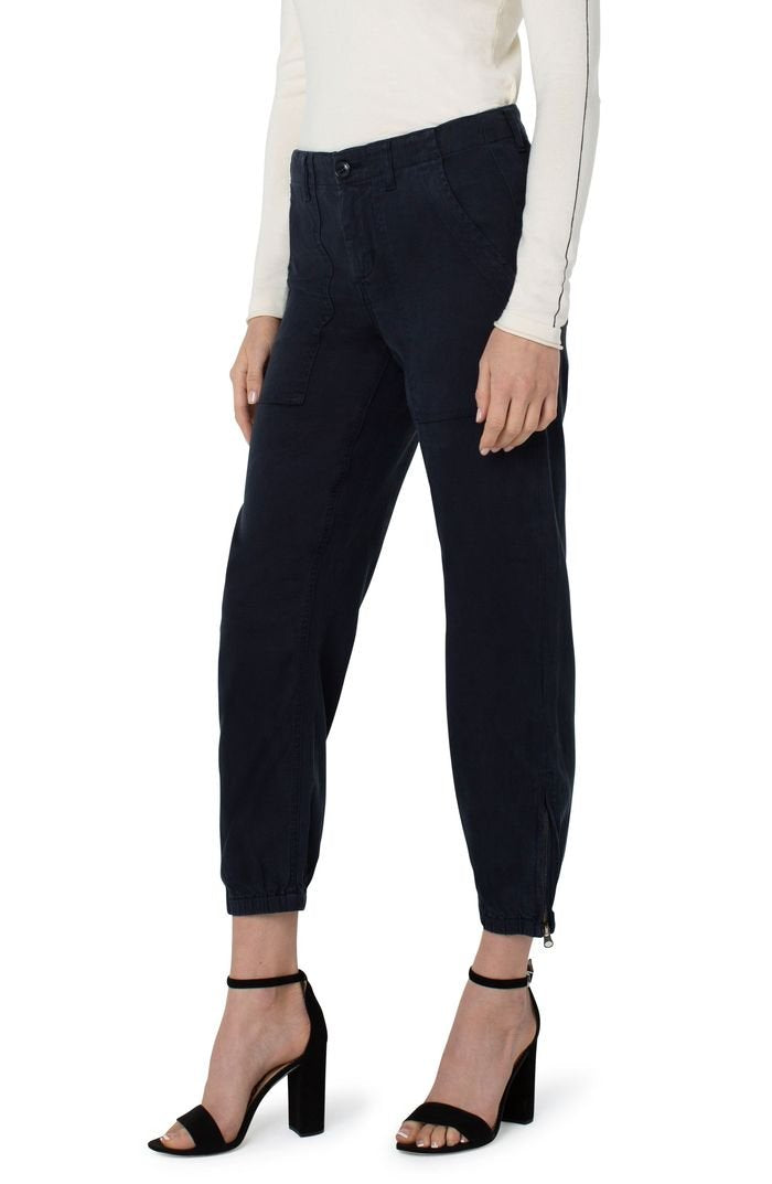 Woman wearing CARBON CLUE UTILITY PANTS with zip hem, styled with trendy coastal style at Raggdoll Boutique.