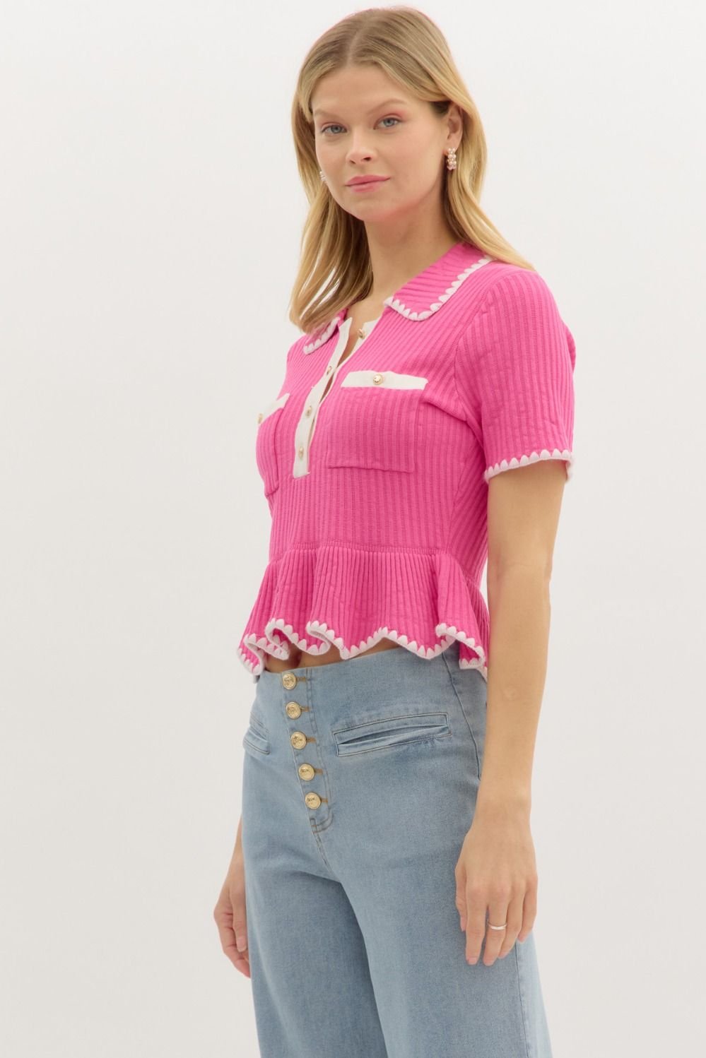 Stylish pink sweater crop top with white trim, perfect for beach dresses and curated women's fashion at a coastal boutique.