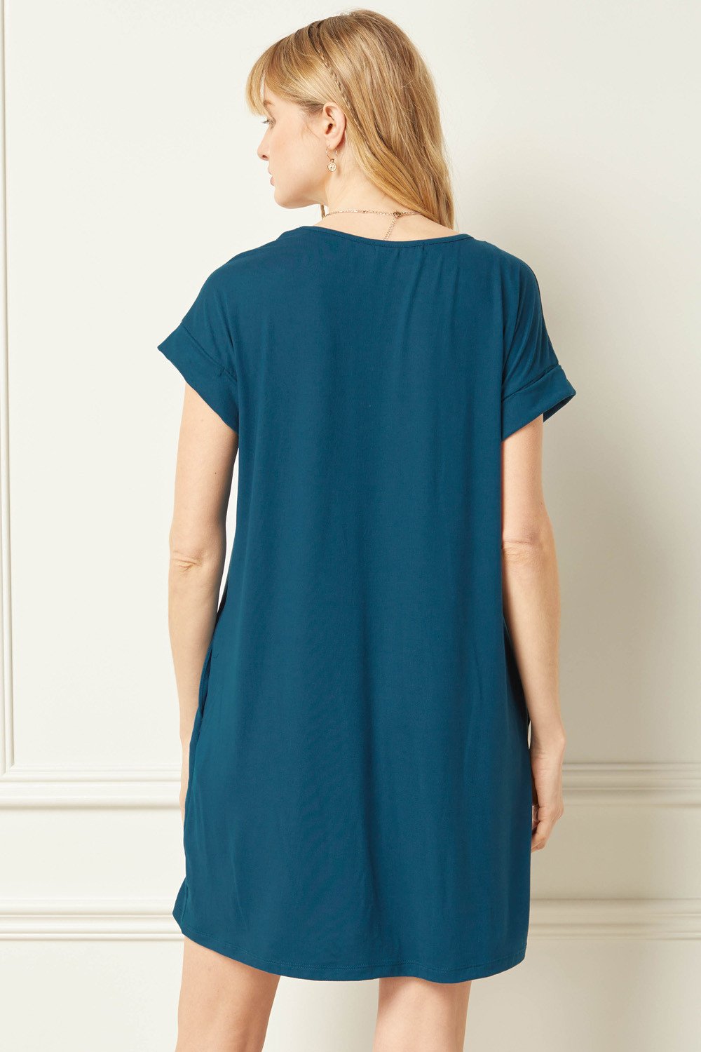 Everyday dress in teal displayed from the back, showcasing the rolled sleeves and lightweight fabric.