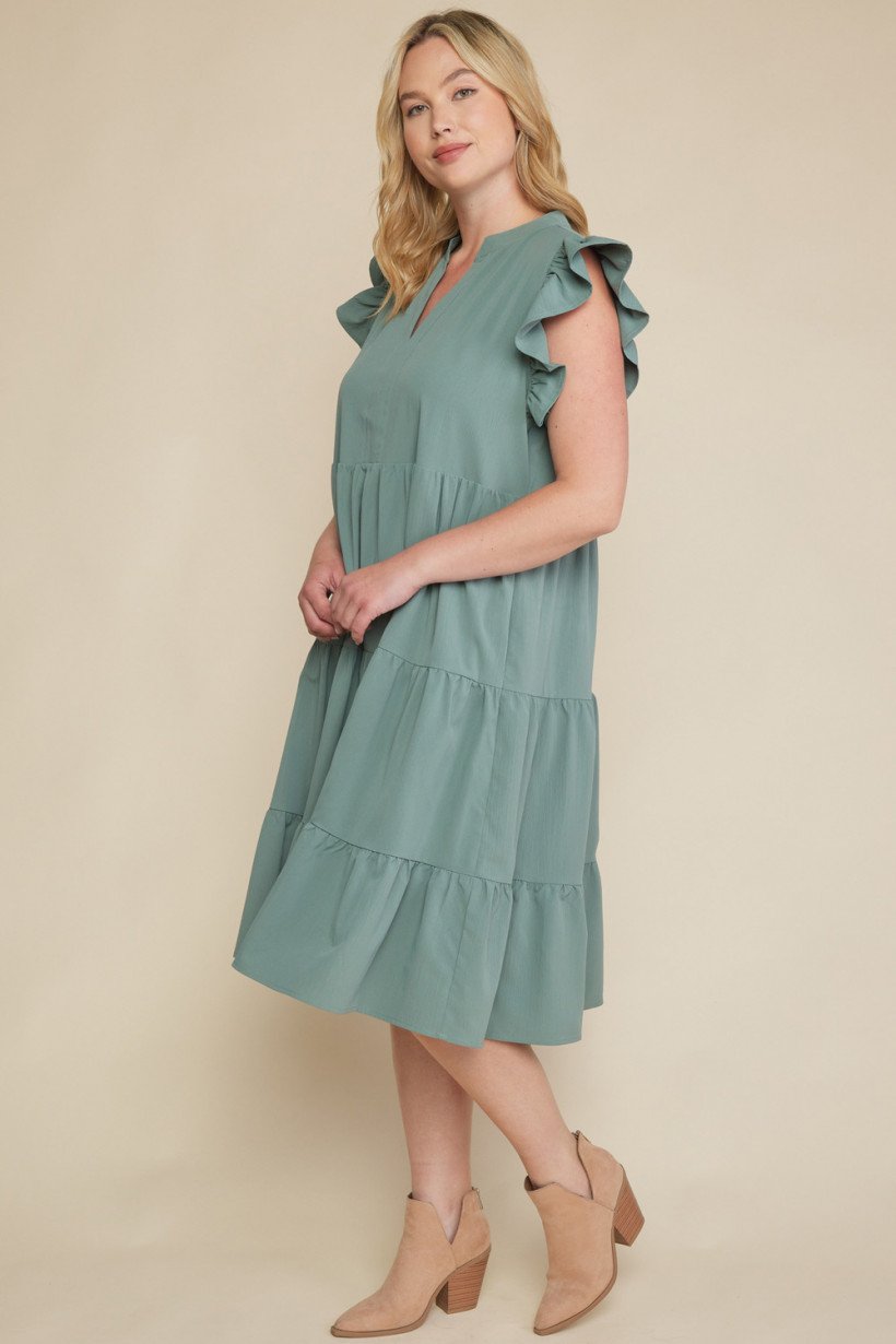 MADE FOR YOU DRESS IN SAGE showcased by a model with ruffled sleeves in a trendy coastal style.
