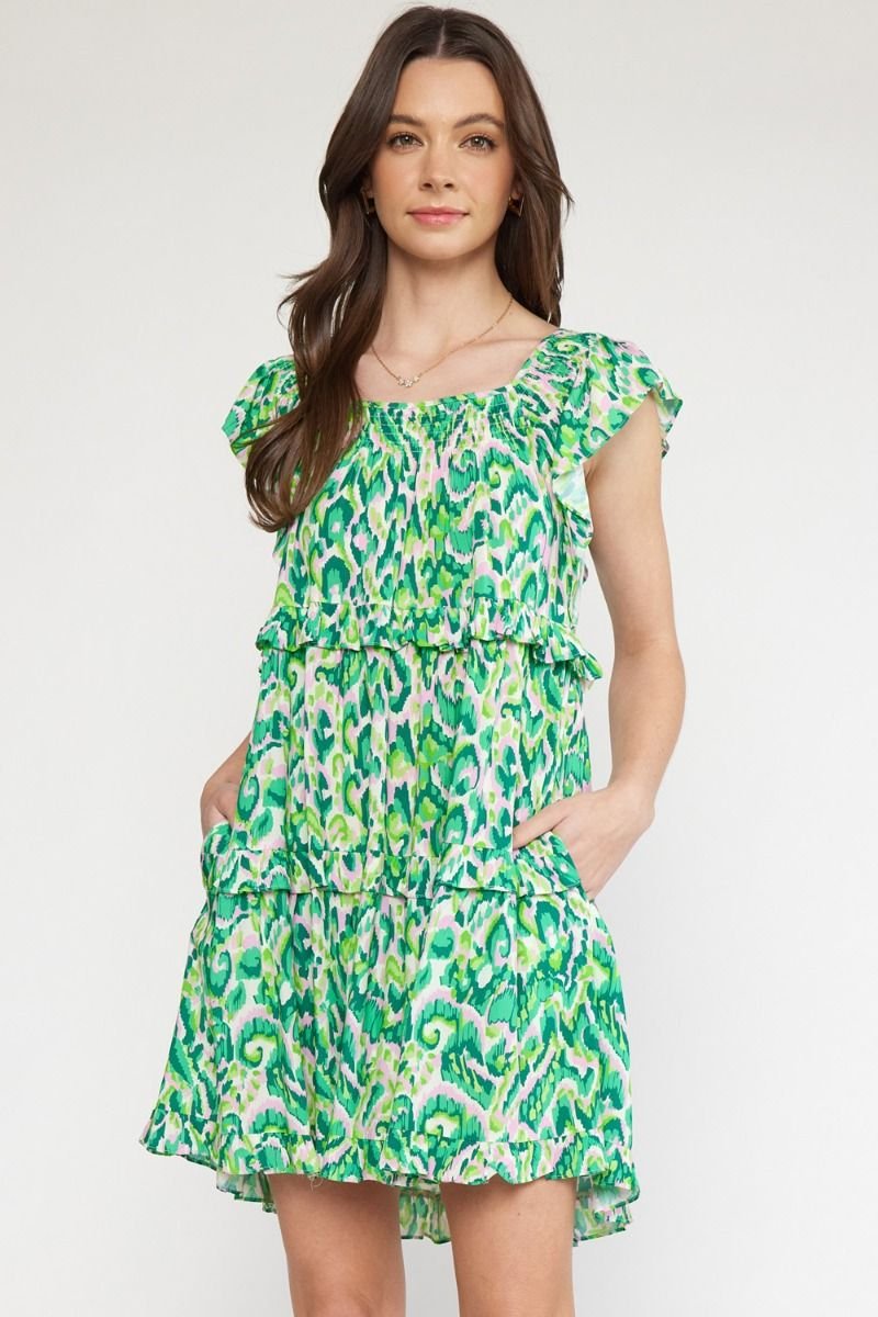 Girls Love Swirls dress from Port Aransas boutique, perfect for tropical vacations, featuring 100% cotton in vibrant green pattern.