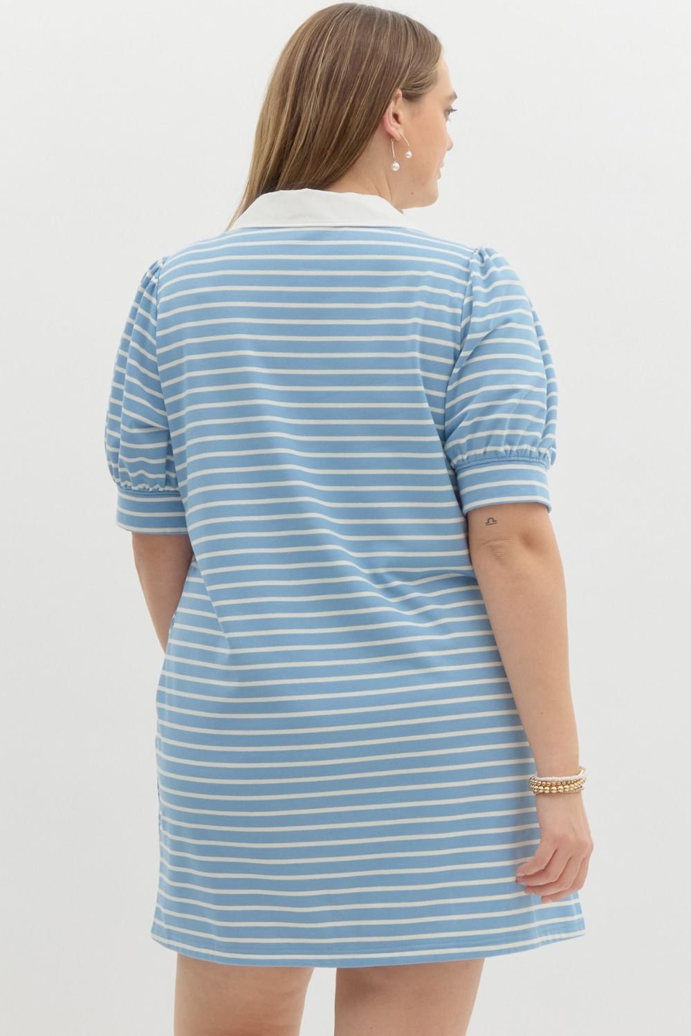 Back view of a woman in a blue and white striped plus dress, showcasing stylish coastal boutique clothing for summer.