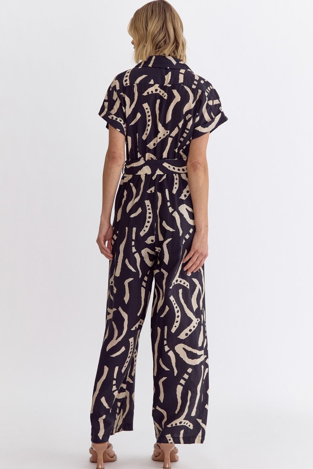 Women wearing a BLACK PRINT DETAIL JUMPSUIT from Raggdoll Boutique, showcasing trendy coastal style.