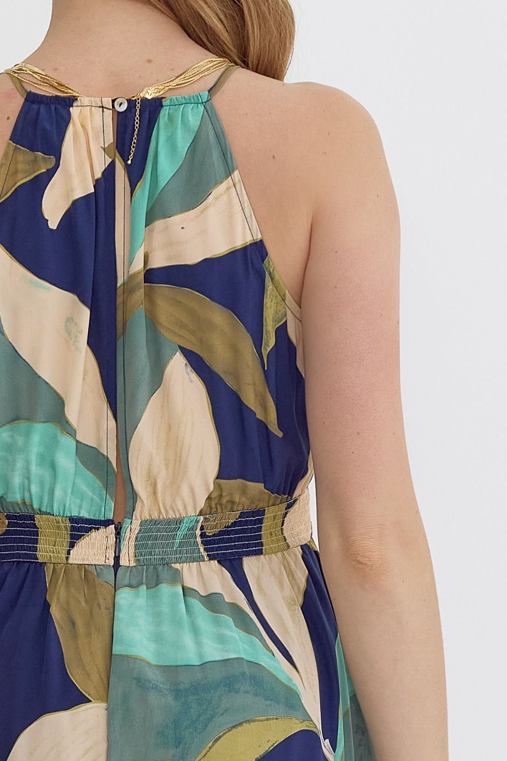 Back view of a navy and green jumpsuit showcasing tropical leaf patterns, ideal for coastal boutique clothing and stylish tops for women.