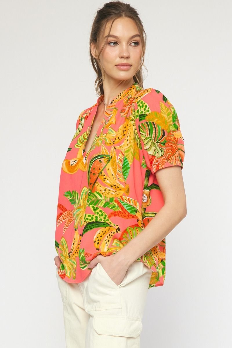 Stylish pink multi-top featuring tropical prints, perfect for beach days or vacations. Ideal for coastal boutique clothing lovers.