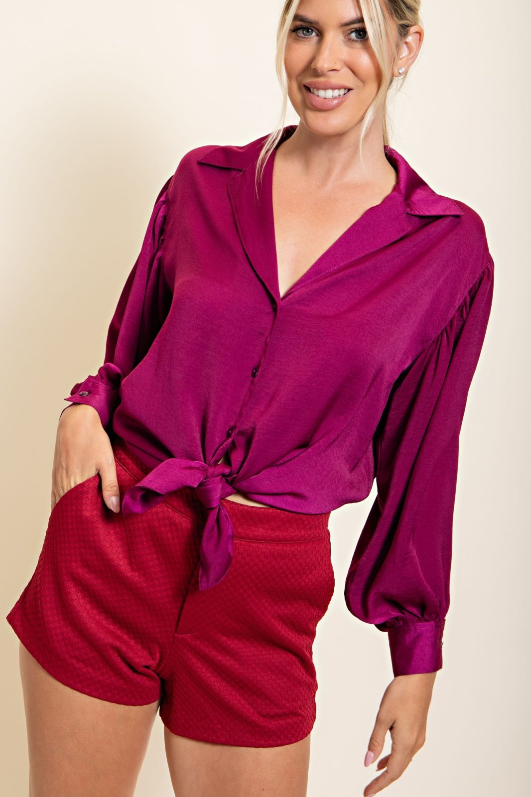 Model wearing PLUM SATIN TIE-FRONT TOP paired with stylish shorts from Raggdoll Boutique.