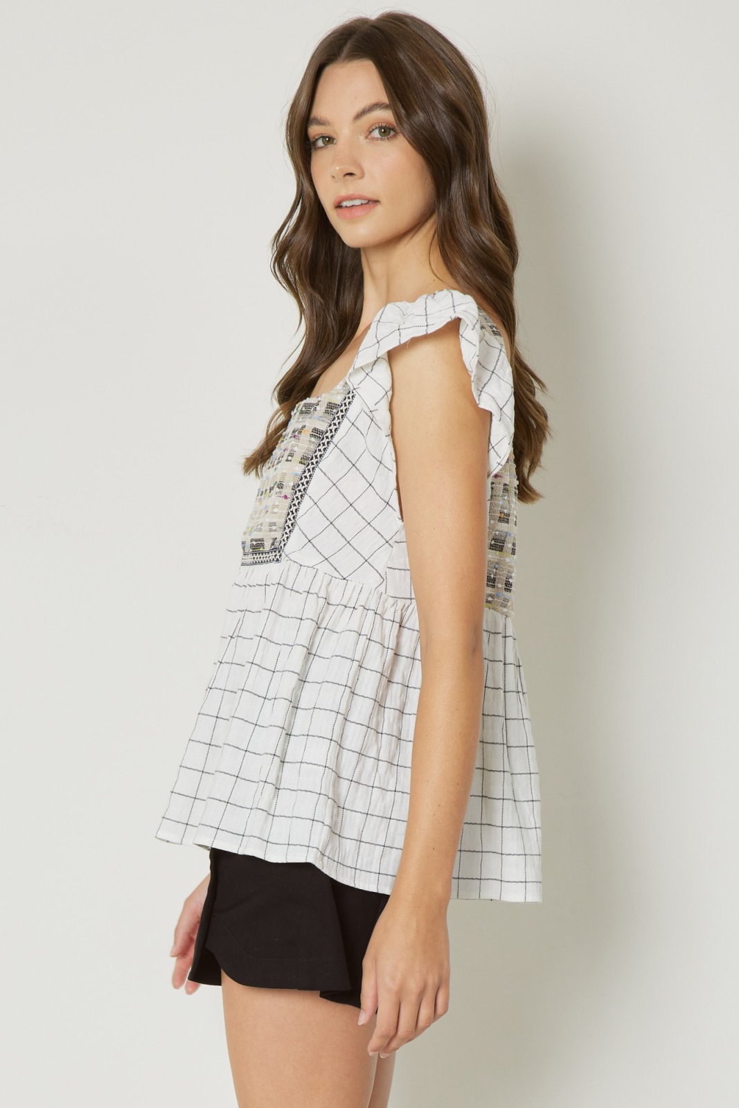 Stylish cream babydoll top with detail, perfect for coastal boutique clothing and tropical vacation dresses.