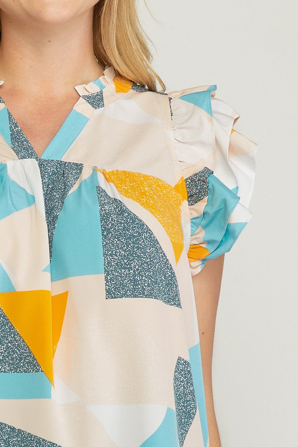 PLUS GOLD ABSTRACT TOP at Raggdoll Boutique, showcasing trendy coastal style with colorful geometric patterns.