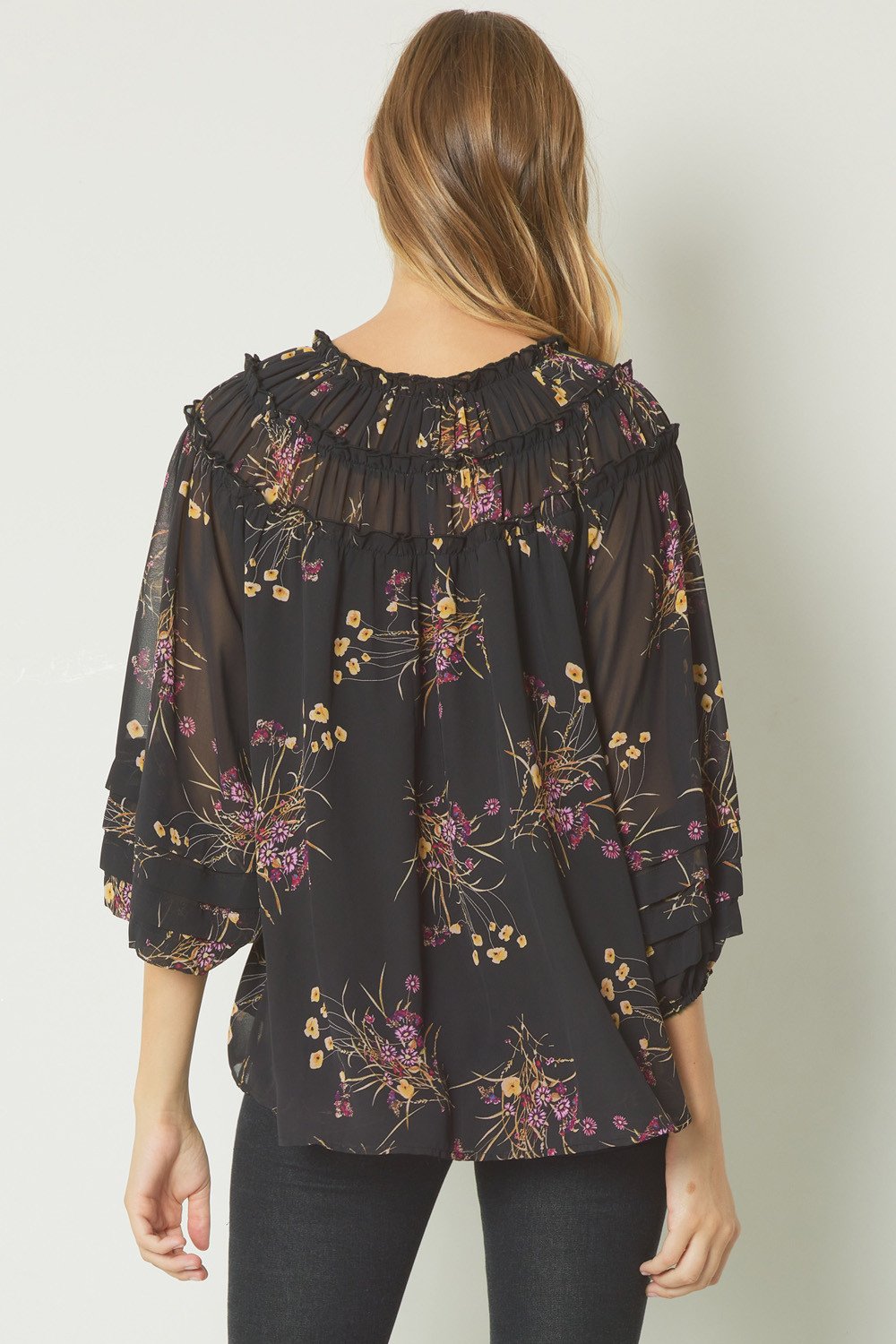 BACK VIEW OF BLACK FLORAL TOP WITH SLEEVE DETAIL AT RAGGDOLL BOUTIQUE, TRENDY COASTAL STYLE.